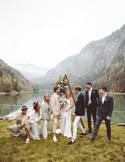 Photos de groupe d'amis lors d'un mariage au bord d'un lac entourés de montagne